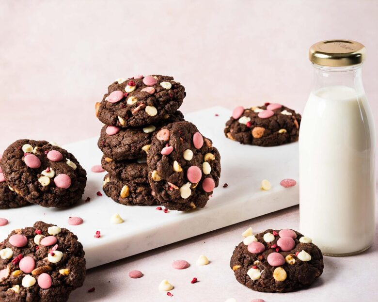 Raspberry ruby chocolate cookies. Deeply dark and chewy chocolate cookies packed with oodles of white and ruby chocolate chips and freeze dried raspberries. Recipe by movers and bakers
