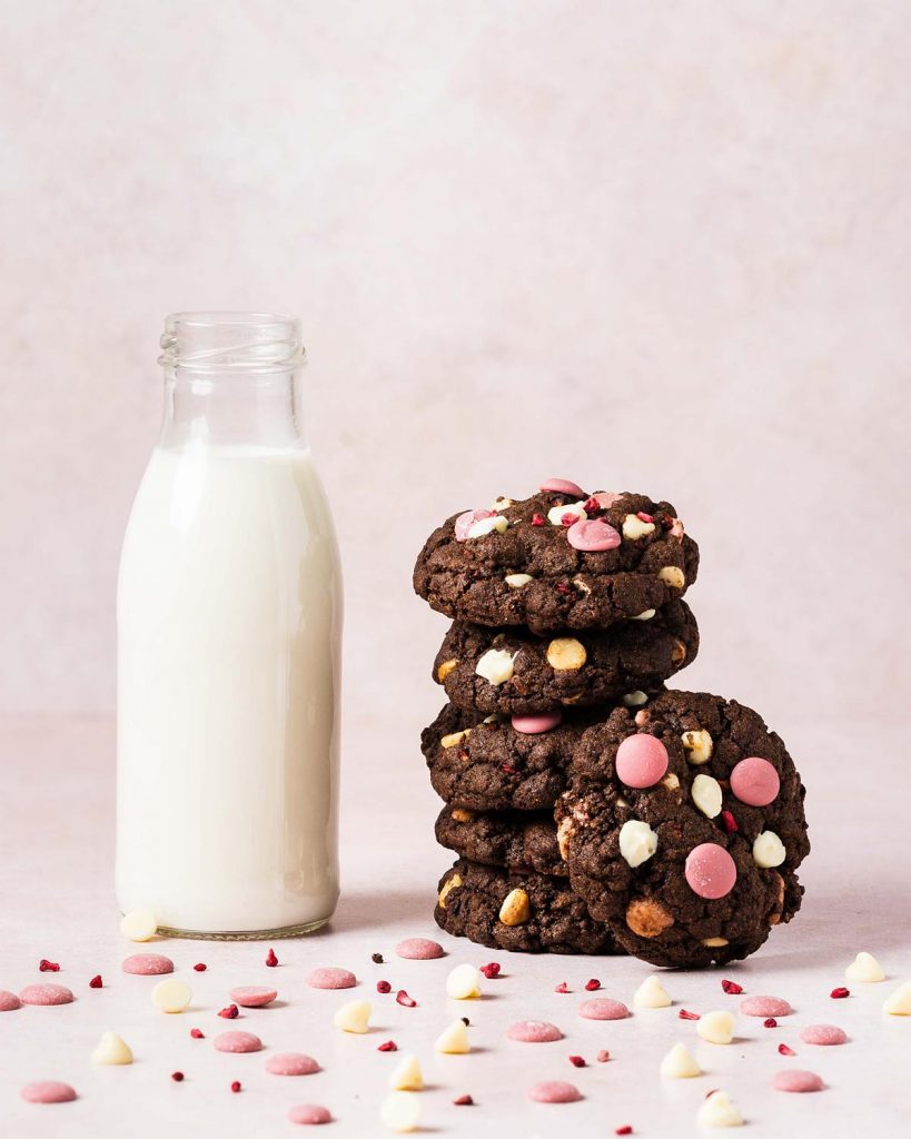 Raspberry ruby chocolate cookies. Deeply dark and chewy chocolate cookies packed with oodles of white and ruby chocolate chips and freeze dried raspberries. Recipe by movers and bakers