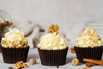 Carrot cake cupcakes. Moist and fluffy spiced carrot cake cupcakes with walnuts topped with a delicious tangy cream cheese frosting and decorated with walnuts. Recipe by movers and bakers