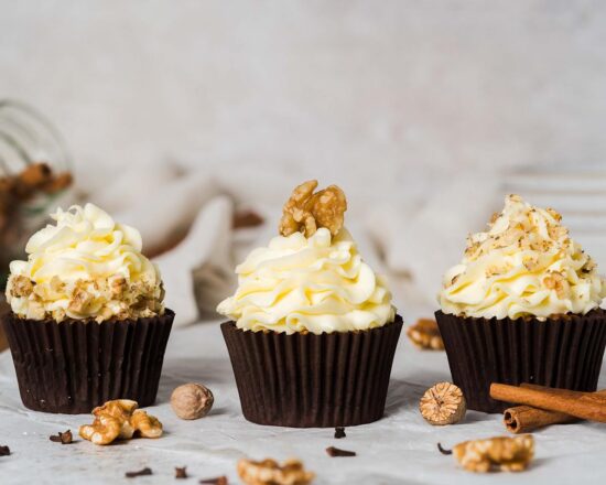Carrot cake cupcakes. Moist and fluffy spiced carrot cake cupcakes with walnuts topped with a delicious tangy cream cheese frosting and decorated with walnuts. Recipe by movers and bakers
