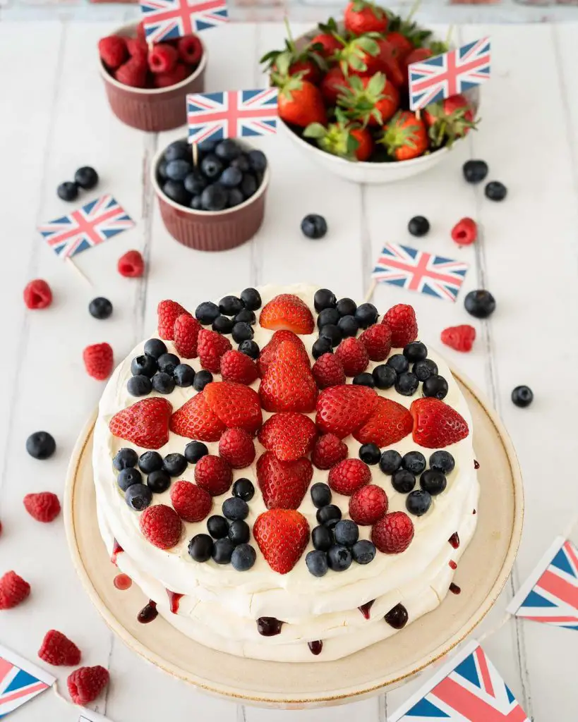 This Union Jack meringue cake has layers of crispy and chewy meringue filled with a creamy mascarpone filling and blackberry jam and is topped with plenty of delicious fresh berries in a Union Jack design! Recipe by movers and bakers