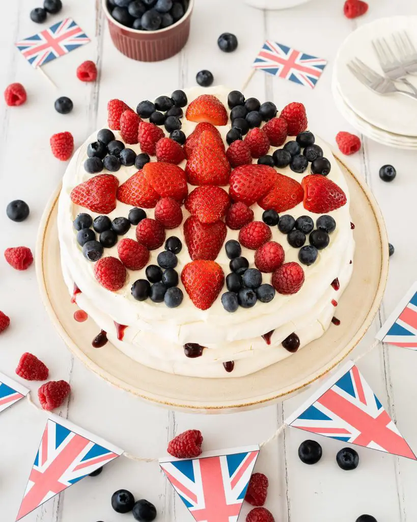 This Union Jack meringue cake has layers of crispy and chewy meringue filled with a creamy mascarpone filling and blackberry jam and is topped with plenty of delicious fresh berries in a Union Jack design! Recipe by movers and bakers