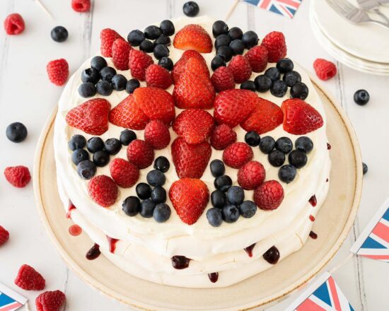 This Union Jack meringue cake has layers of crispy and chewy meringue filled with a creamy mascarpone filling and blackberry jam and is topped with plenty of delicious fresh berries in a Union Jack design! Recipe by movers and bakers