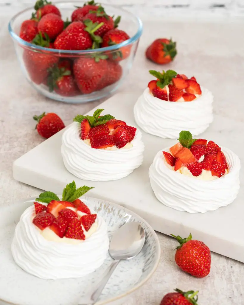 Eton mess mini pavlova nests. A perfect mash up for a summertime dessert, combining delicious pavlova with fresh strawberries and softly whipped cream. Recipe by movers and bakers