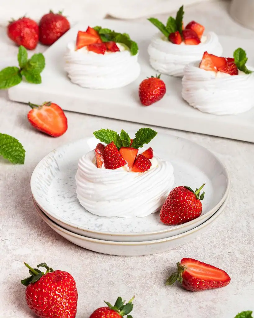Eton mess mini pavlova nests. A perfect mash up for a summertime dessert, combining delicious pavlova with fresh strawberries and softly whipped cream. Recipe by movers and bakers