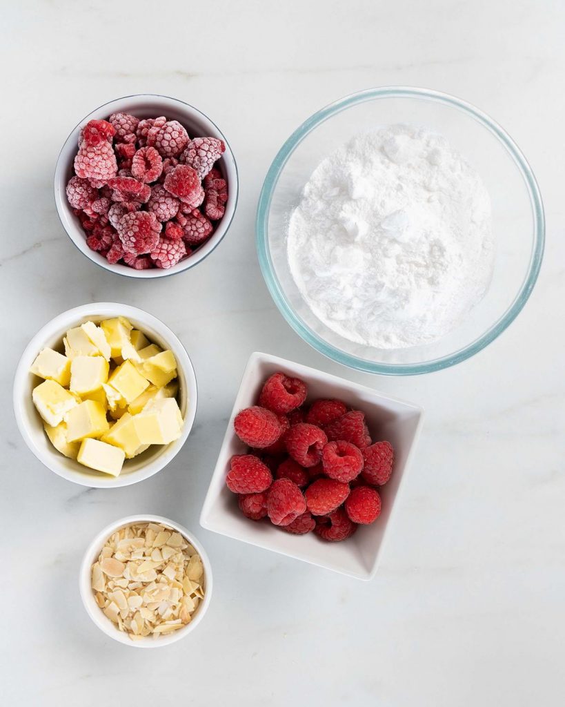 Ingredients required for the buttercream: raspberries, dairy free block butter, icing (powdered) sugar and flaked almonds. Recipe by movers and bakers