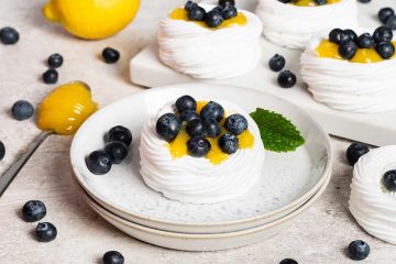 Lemon blueberry mini pavlova nests. Melt in your mouth meringue, soft whipped cream, lemon curd and plenty of blueberries make this a summertime dessert dream! Recipe by movers and bakers