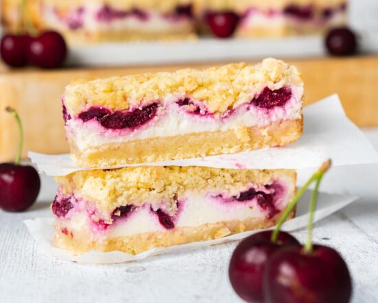 Cherry cheesecake bars. Delicious shortbread, creamy eggless baked cheesecake and rich cherry pie filling topped with more shortbread crumbs. This is one cheesecake no one can turn down! Recipe by movers and bakers