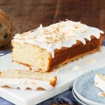 Vegan coconut cake. A light, fluffy and moist coconut cake, drizzled in a glorious coconut glaze and topped with toasted coconut shavings. Coconut tropical heaven! Recipe by movers and bakers
