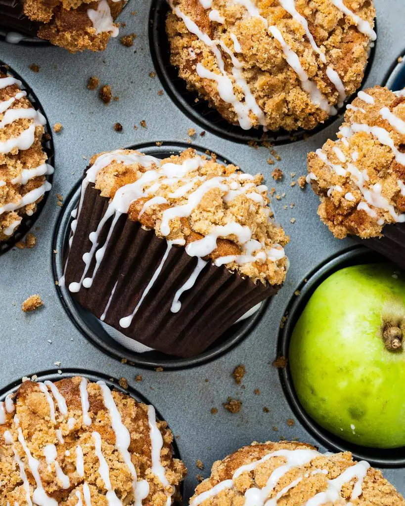 Apple cinnamon muffins. Tender and moist muffins packed with apple and cinnamon flavour topped with a beautiful crunchy cinnamon streusel topping. Recipe by movers and bakers