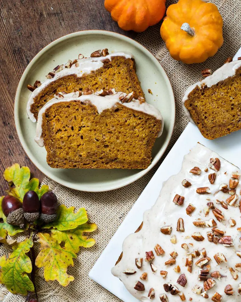 My pumpkin spice loaf cake is moist and delicate, gently spiced with warm pumpkin spice and topped with an irresistible maple spiced glaze and pecan pieces. Recipe by movers and bakers