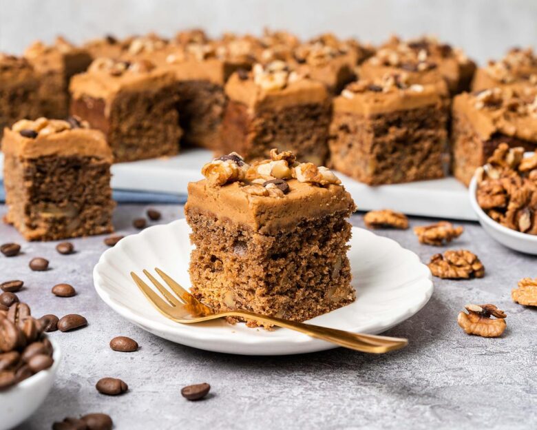 My coffee and walnut traybake is an incredibly moreish bake, with a light and fluffy coffee sponge cake dotted with walnuts throughout, topped with a silky coffee buttercream and decorated with more walnuts and coffee beans. Perfect for feeding a crowd! Recipe by movers and bakers
