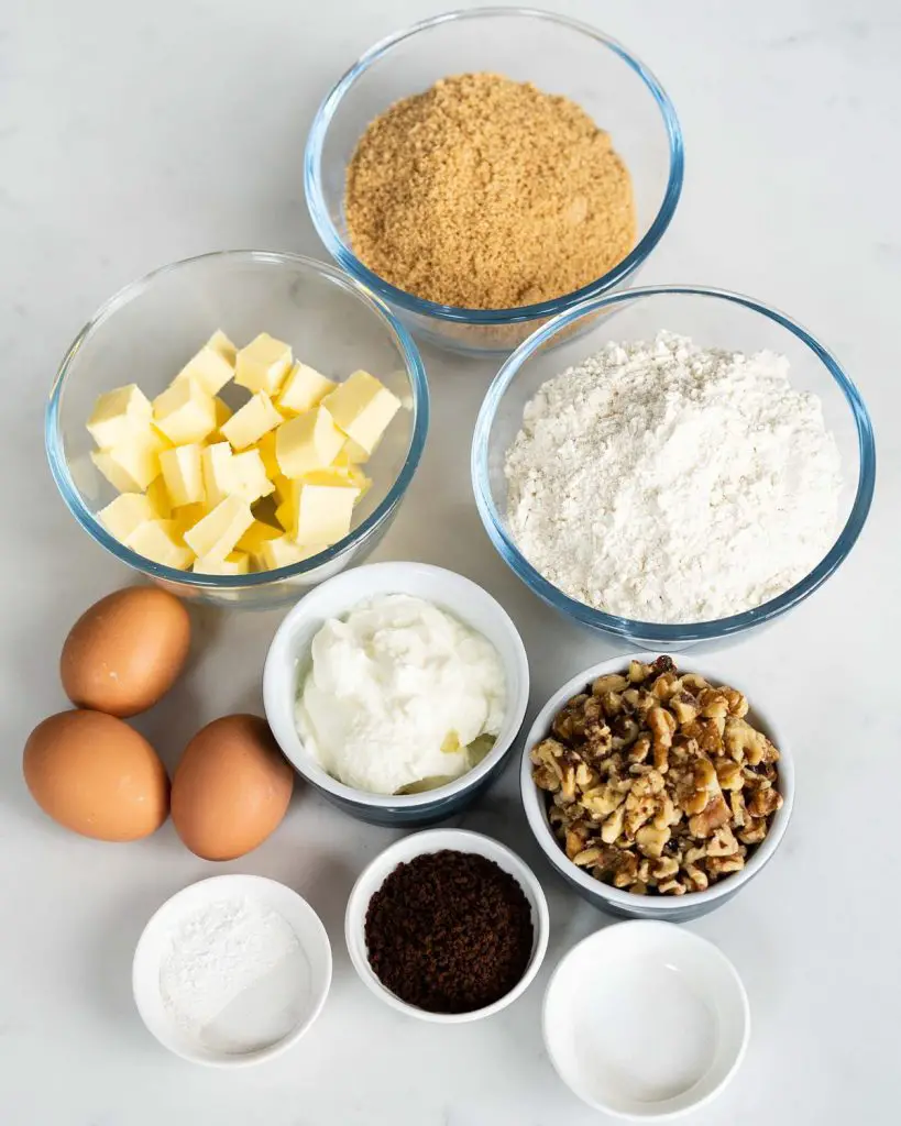Ingredients required: unsalted butter, brown sugar, plain (all purpose) flour, baking powder, bicarbonate of soda (baking soda), salt, eggs, yogurt, instant coffee granules, walnuts, icing sugar and vanilla. Recipe by movers and bakers