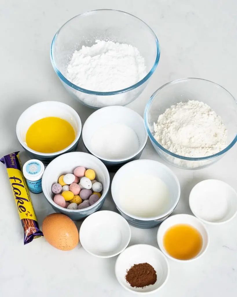 Ingredients required: plain (all purpose) flour, caster sugar, baking powder, bicarbonate of soda (baking soda), salt, egg, milk, unsalted butter, vanilla, icing sugar, cocoa, flakes and mini eggs. Recipe by movers and bakers