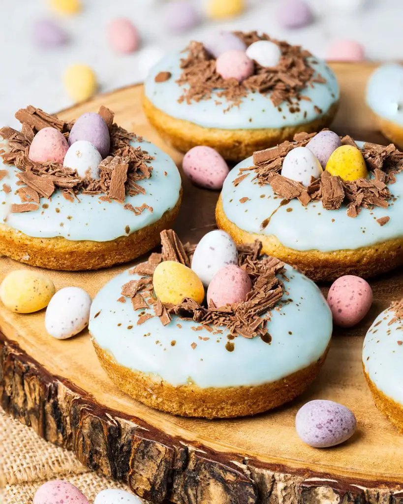 Easter donuts. Light and fluffy vanilla donuts, topped with a duck egg speckled vanilla glaze, a chocolate nest and delicious mini eggs. The perfect Easter treat! Recipe by movers and bakers