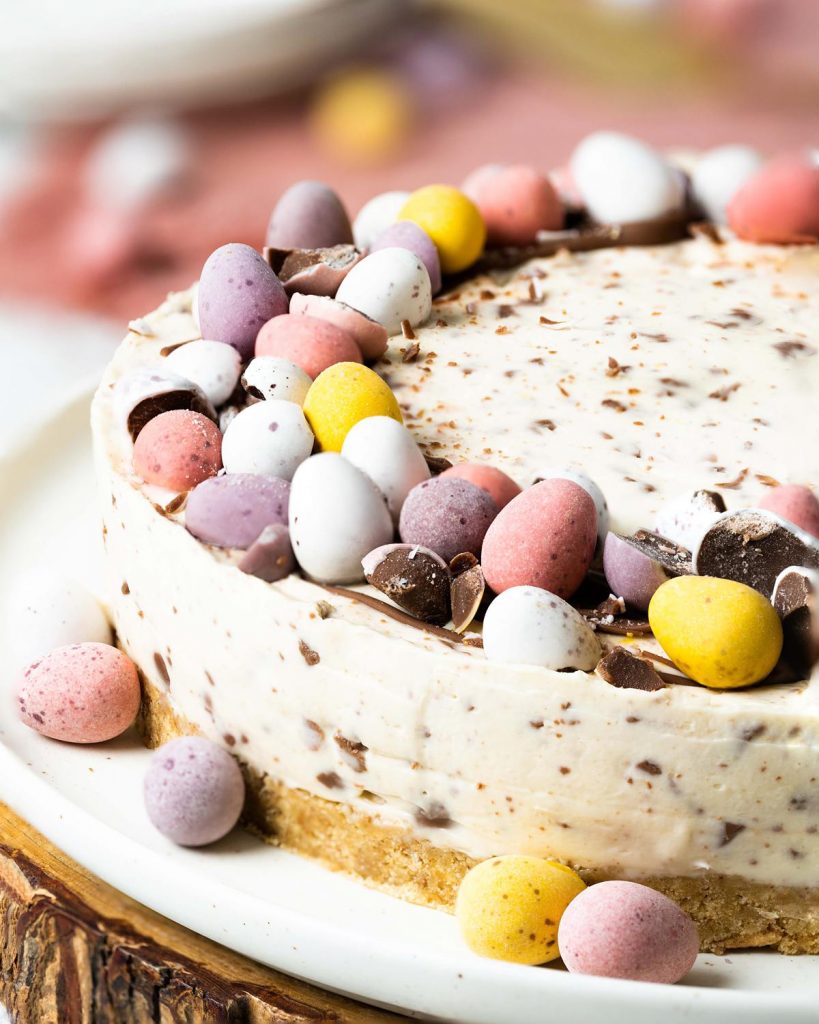 My no bake mini egg cheesecake is wonderfully simple to make and just too good to resist! Decorated simply with a halo of melted chocolate and mini eggs, this beautiful dessert is a sure crowd pleaser! Recipe by movers and bakers