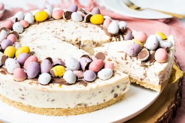 My no bake mini egg cheesecake is wonderfully simple to make and just too good to resist! Decorated simply with a halo of melted chocolate and mini eggs, this beautiful dessert is a sure crowd pleaser! Recipe by movers and bakers