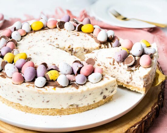 My no bake mini egg cheesecake is wonderfully simple to make and just too good to resist! Decorated simply with a halo of melted chocolate and mini eggs, this beautiful dessert is a sure crowd pleaser! Recipe by movers and bakers