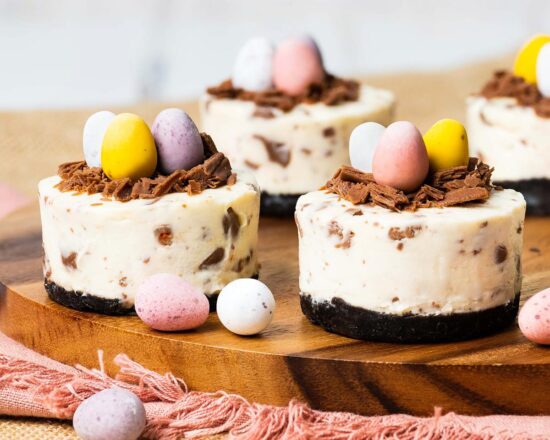 My mini egg cheesecakes are perfectly adorable, individual cheesecakes with a chocolate biscuit base, a creamy cheesecake filling packed with mini eggs, and a chocolate nest with even more mini eggs to decorate. Heavenly! Recipe by movers and bakers