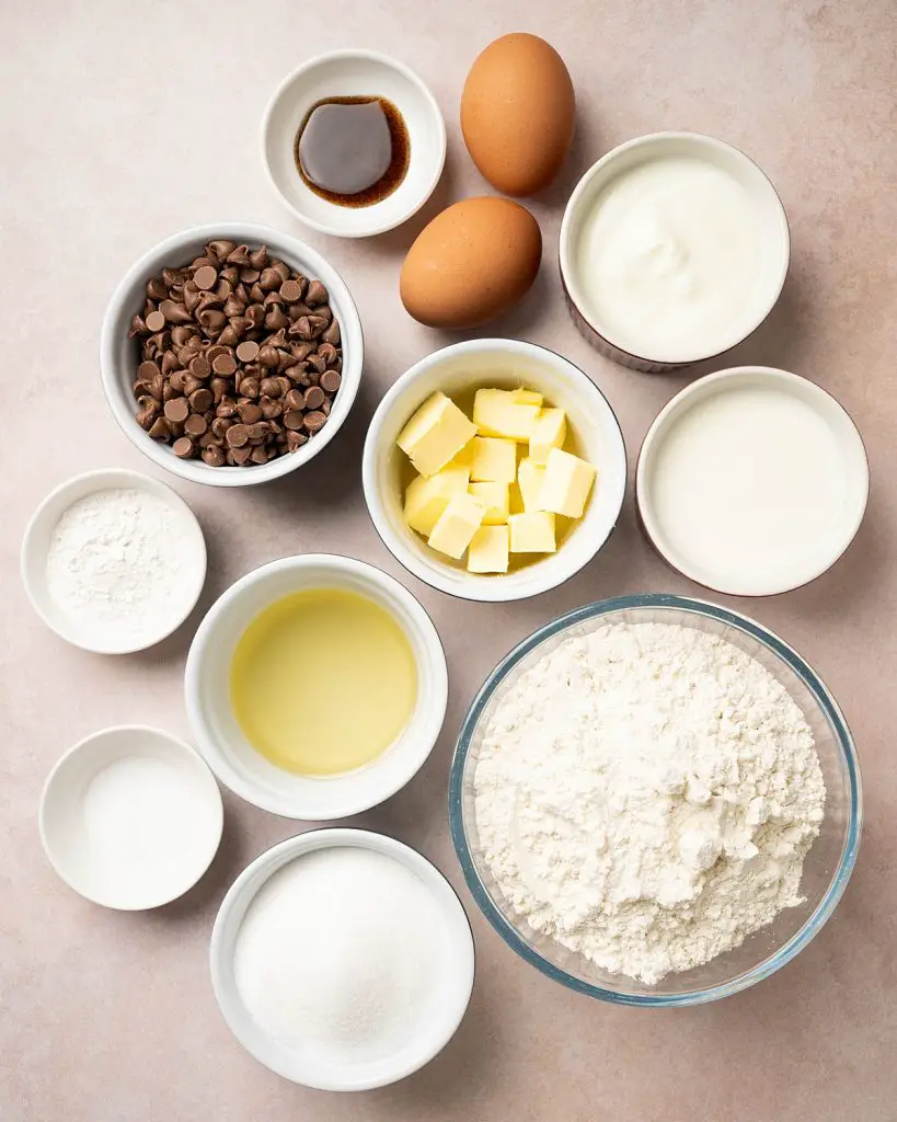 Ingredients required: plain (all purpose) flour, caster sugar, salt, baking powder, milk, yogurt, vanilla, oil, unsalted butter, chocolate chips and demerara sugar. Recipe by movers and bakers