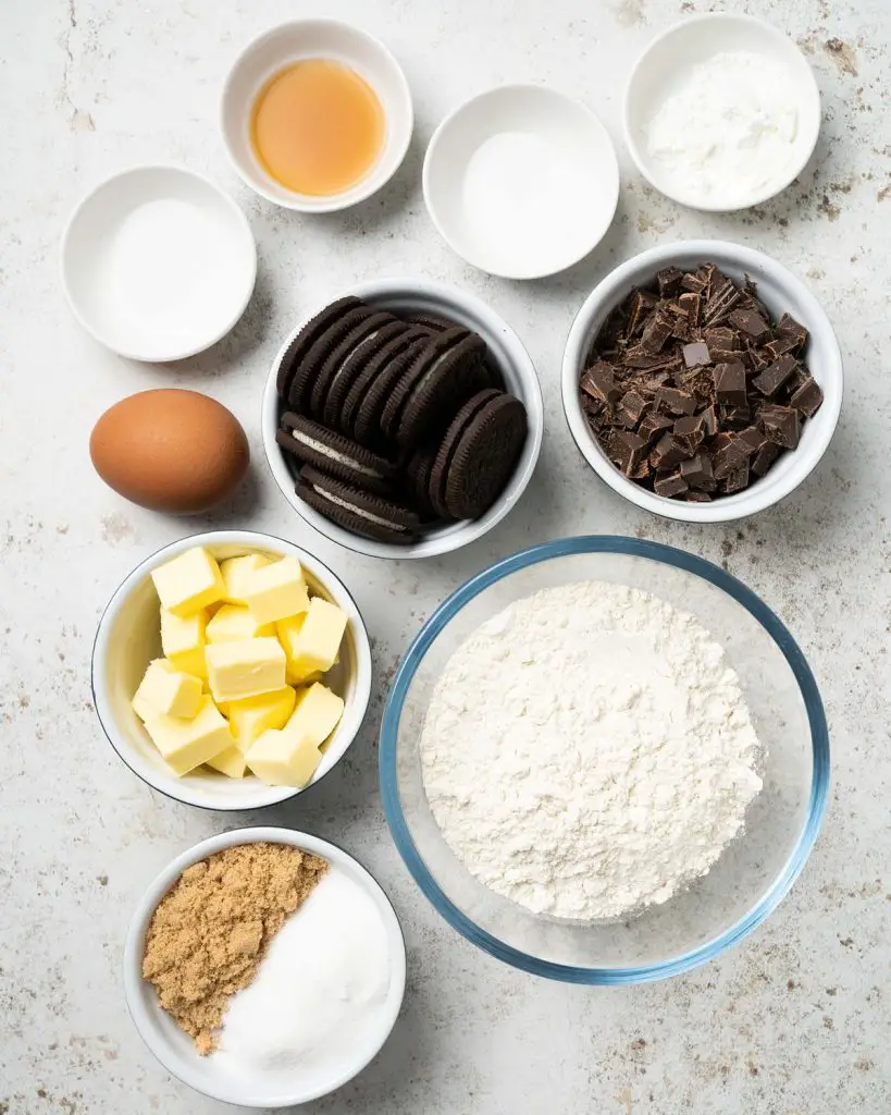 Ingredients required: unsalted butter, caster sugar, brown sugar, vanilla, plain (all purpose) flour, cornflour (cornstarch), bicarbonate of soda (baking soda), salt, Oreo biscuits, dark chocolate and egg. Recipe by movers and bakers