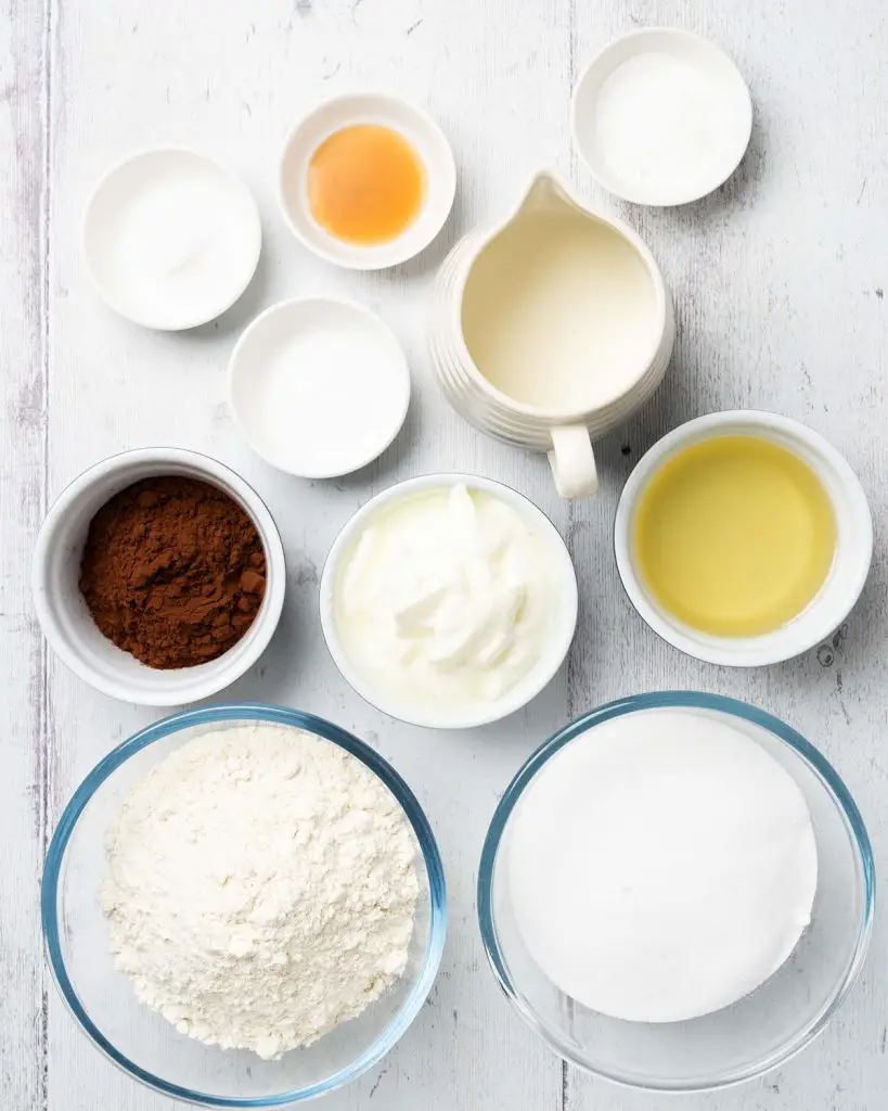 Ingredients required for the cake: plain (all purpose) flour, cocoa powder, caster sugar, baking powder, bicarbonate of soda (baking soda), salt, oil, yogurt, milk and vanilla. Recipe by movers and bakers