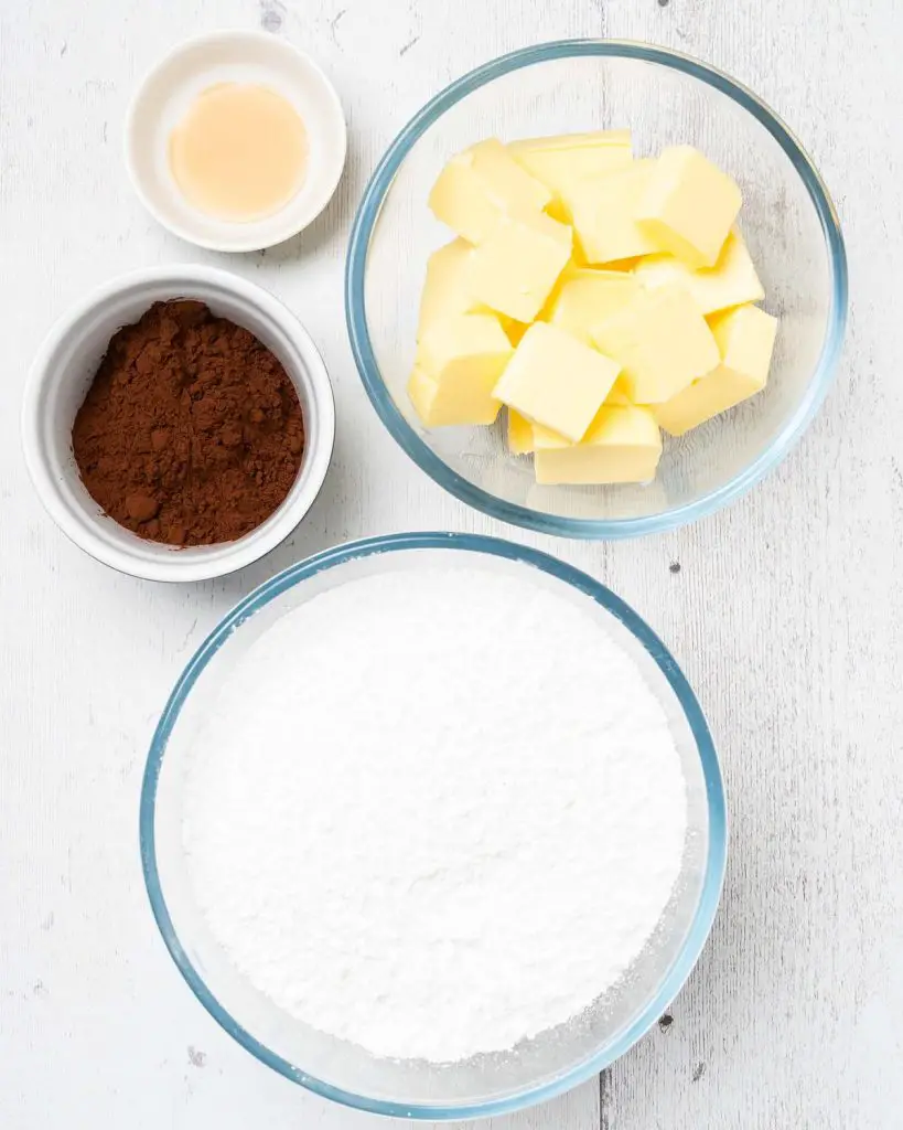 Ingredients for the buttercream: icing (powdered) sugar, unsalted butter, cocoa powder and vanilla. Recipe by movers and bakers