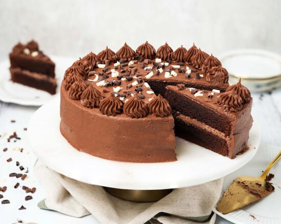 My eggless chocolate cake is light, moist and deeply chocolatey with a smooth chocolate buttercream and crowned with sprinkles. This cake is so good, no one will know it is egg free! Recipe by movers and bakers