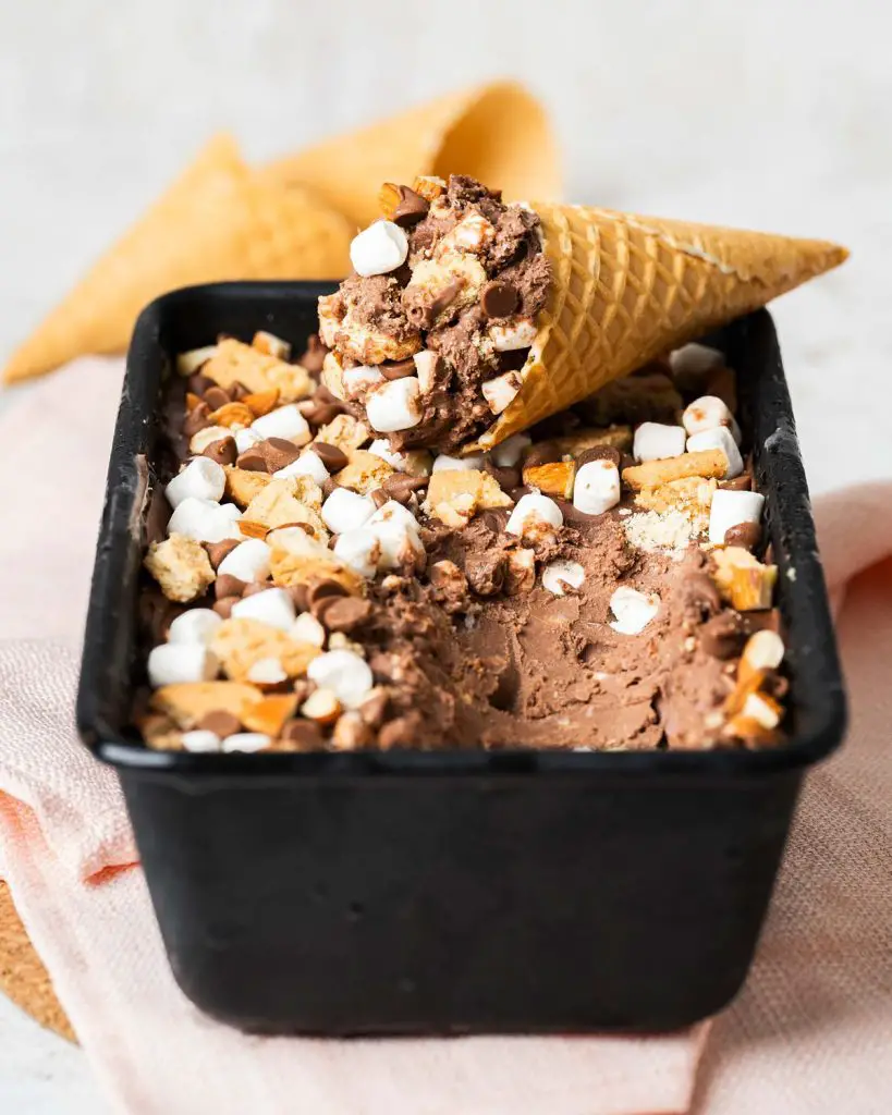 My homemade rocky road ice cream is a deliciously creamy chocolate ice cream packed with plenty of chocolate chips, mini marshmallows, digestive biscuit pieces and chopped almonds for amazing flavour and texture in every bite! Recipe by movers and bakers