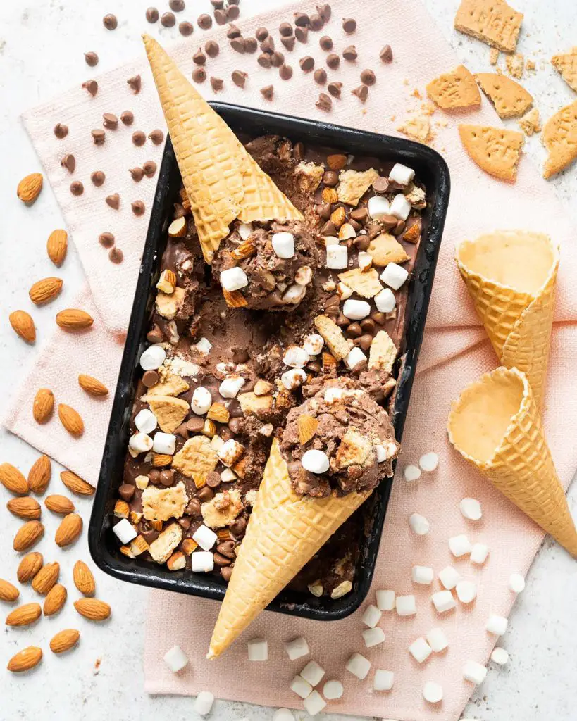 My homemade rocky road ice cream is a deliciously creamy chocolate ice cream packed with plenty of chocolate chips, mini marshmallows, digestive biscuit pieces and chopped almonds for amazing flavour and texture in every bite! Recipe by movers and bakers