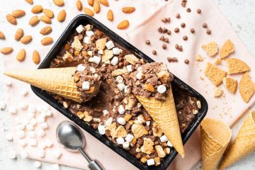 My homemade rocky road ice cream is a deliciously creamy chocolate ice cream packed with plenty of chocolate chips, mini marshmallows, digestive biscuit pieces and chopped almonds for amazing flavour and texture in every bite! Recipe by movers and bakers