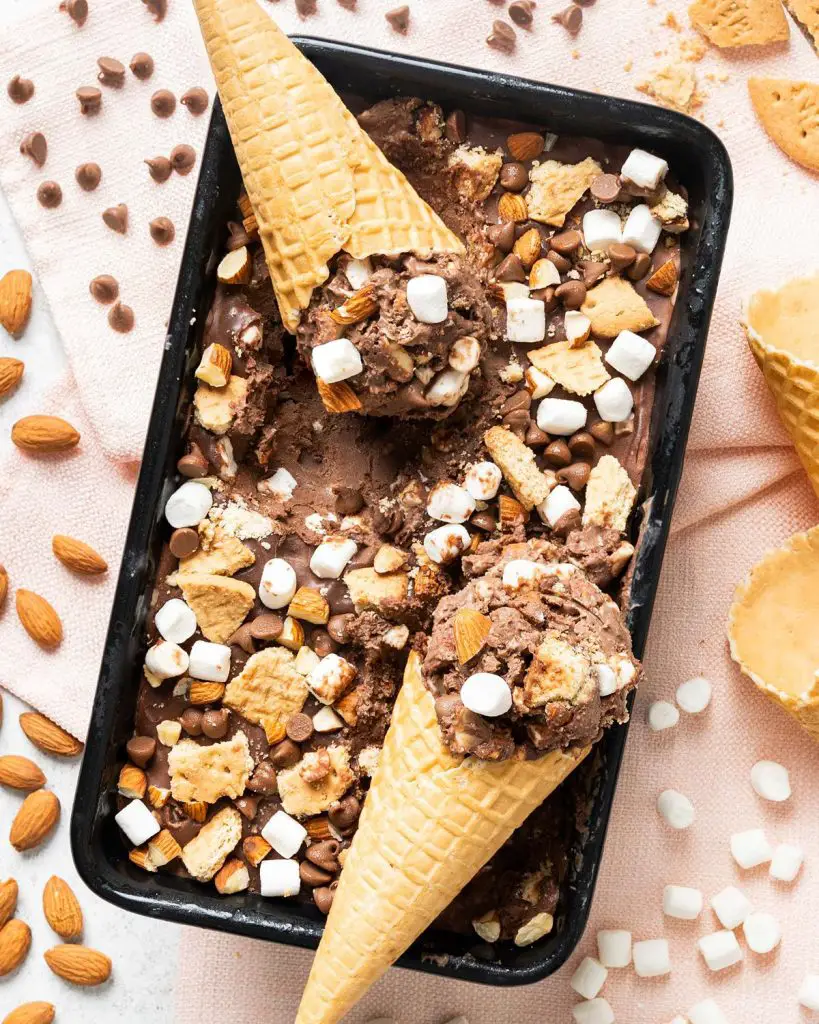 My homemade rocky road ice cream is a deliciously creamy chocolate ice cream packed with plenty of chocolate chips, mini marshmallows, digestive biscuit pieces and chopped almonds for amazing flavour and texture in every bite! Recipe by movers and bakers