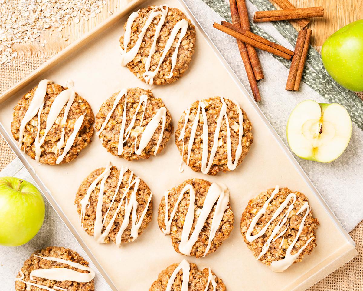 My apple and cinnamon cookies are homely and comforting, with chewy oats and a delicious (optional!) maple drizzle. Recipe by movers and bakers