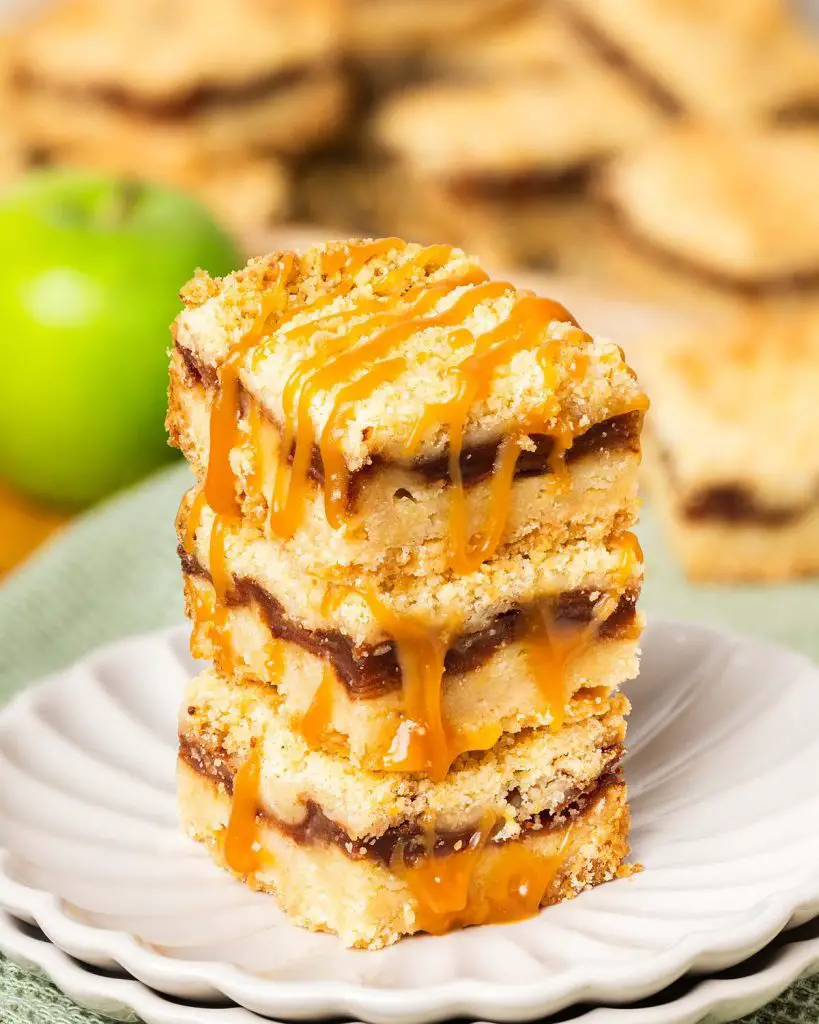 These caramel apple bars have a buttery shortbread base, a delectable cinnamon apple filling and crumbly topping, finished with a beautiful drizzle of caramel. Recipe by movers and bakers