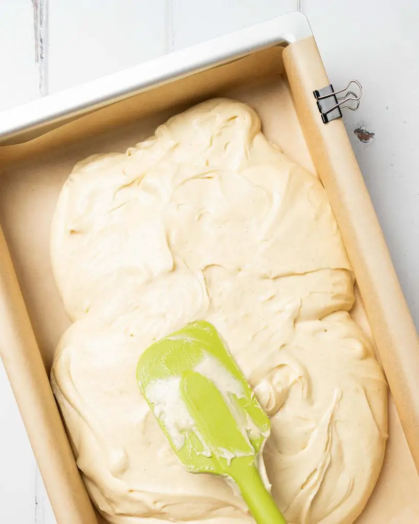 Spreading the cake mixture out evenly in the tin before baking. Recipe by movers and bakers