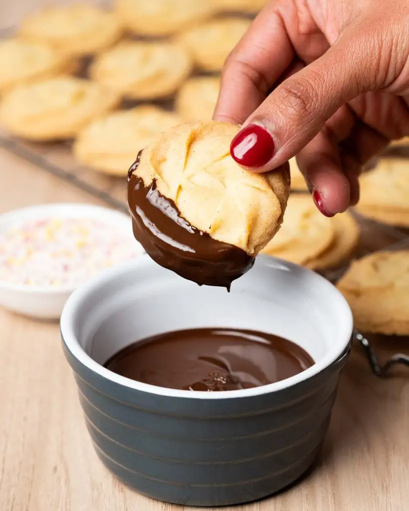 Dip each biscuit into the melted chocolate before topping with sprinkles to finish. Recipe by movers and bakers