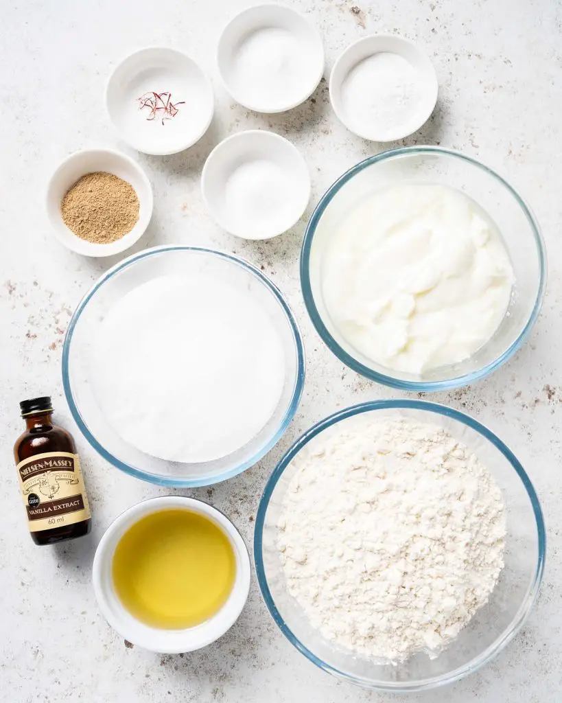 Ingredients for the cake: plain (all purpose) flour, baking powder, salt, yogurt, bicarbonate of soda (baking soda), caster sugar, oil, ground cardamom and saffron. Recipe by movers and bakers