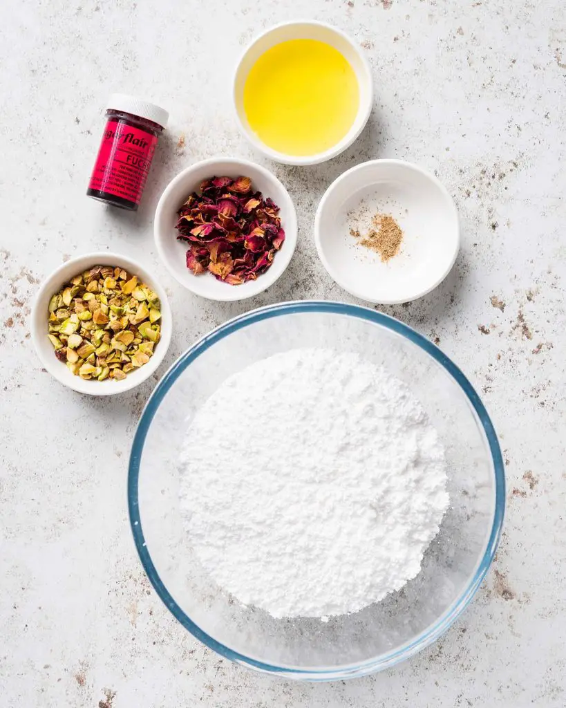 Ingredients for the glaze and decoration: icing (powdered) sugar, ground cardamom, a little of the syrup, pink food colouring, chopped pistachios and dried rose petals. Recipe by movers and bakers