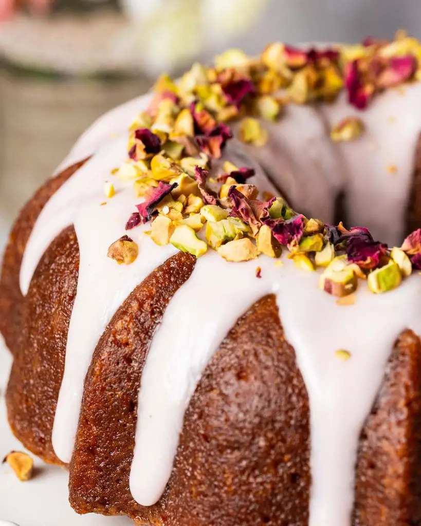 My gulab jamun cake is moist and flavourful and so utterly irresistible! It has an eggless cardamom cake, a deep cardamom and rose water syrup and a pretty pink glaze decorated with chopped pistachios and dried rose petals. The prettiest celebration cake! Recipe by movers and bakers