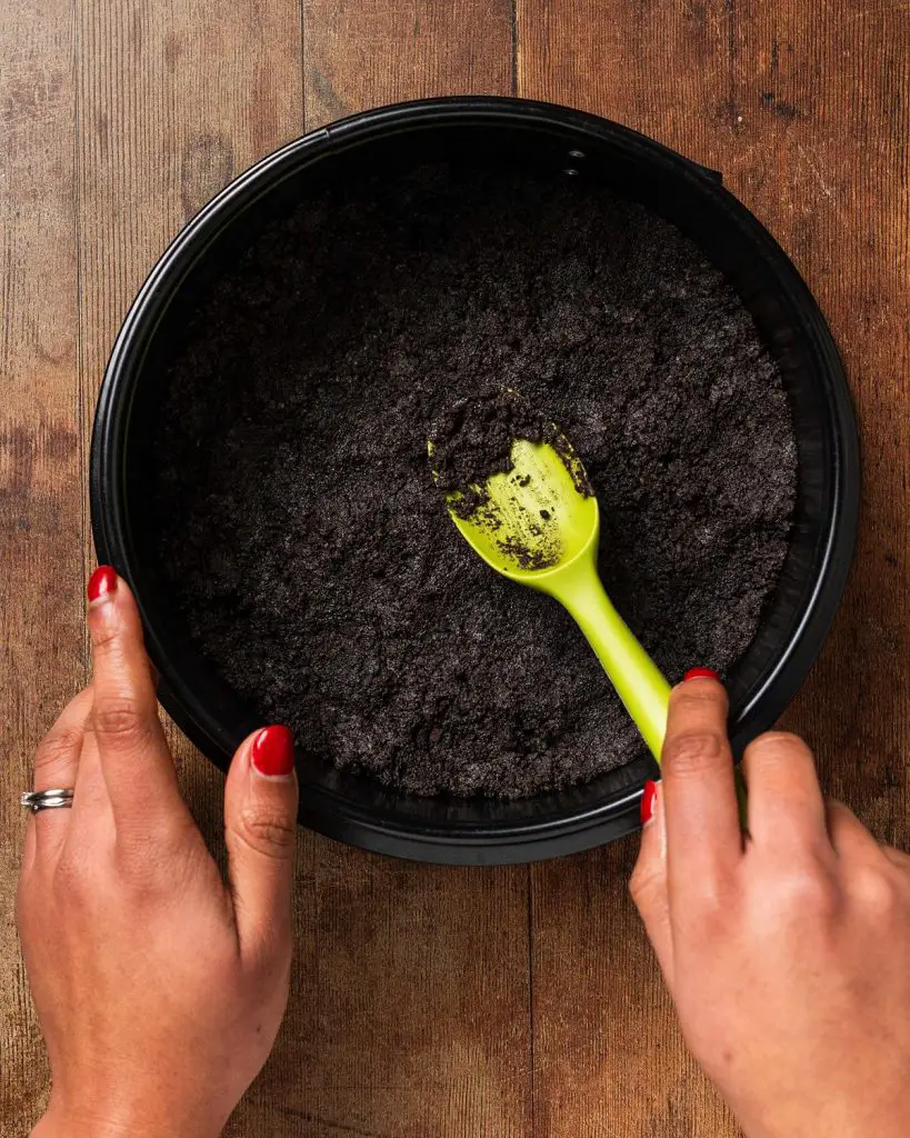 Pressing the base firmly into the tin before chilling in the fridge. Recipe by movers and bakers