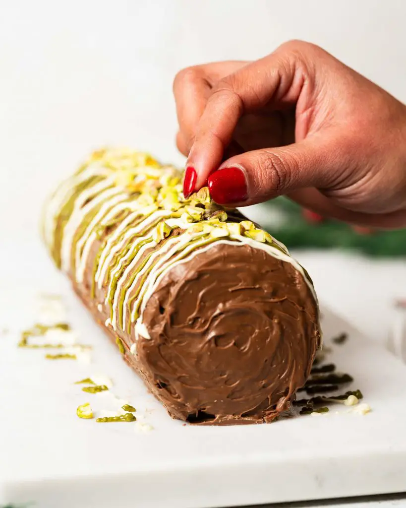 Adding the finishing touches to the finished roll cake. Recipe by movers and bakers