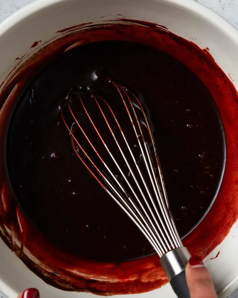 Whisking the sugar mixture with the cocoa and food colour until a deep red colour is achieved...