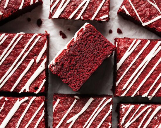 My red velvet brownies are fudgy and chewy, with a perfectly balance flavour, and topped with a scrumptious cream cheese drizzle. Recipe by movers and bakers