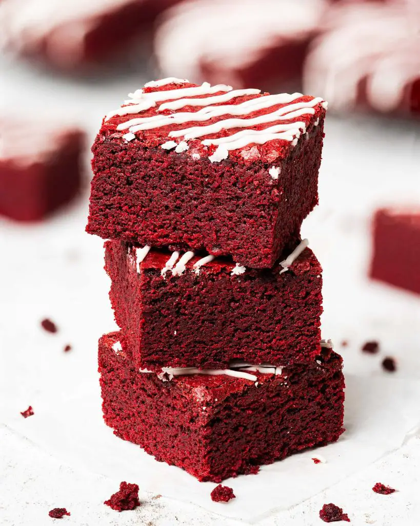 My red velvet brownies are fudgy and chewy, with a perfectly balance flavour, and topped with a scrumptious cream cheese drizzle. Recipe by movers and bakers