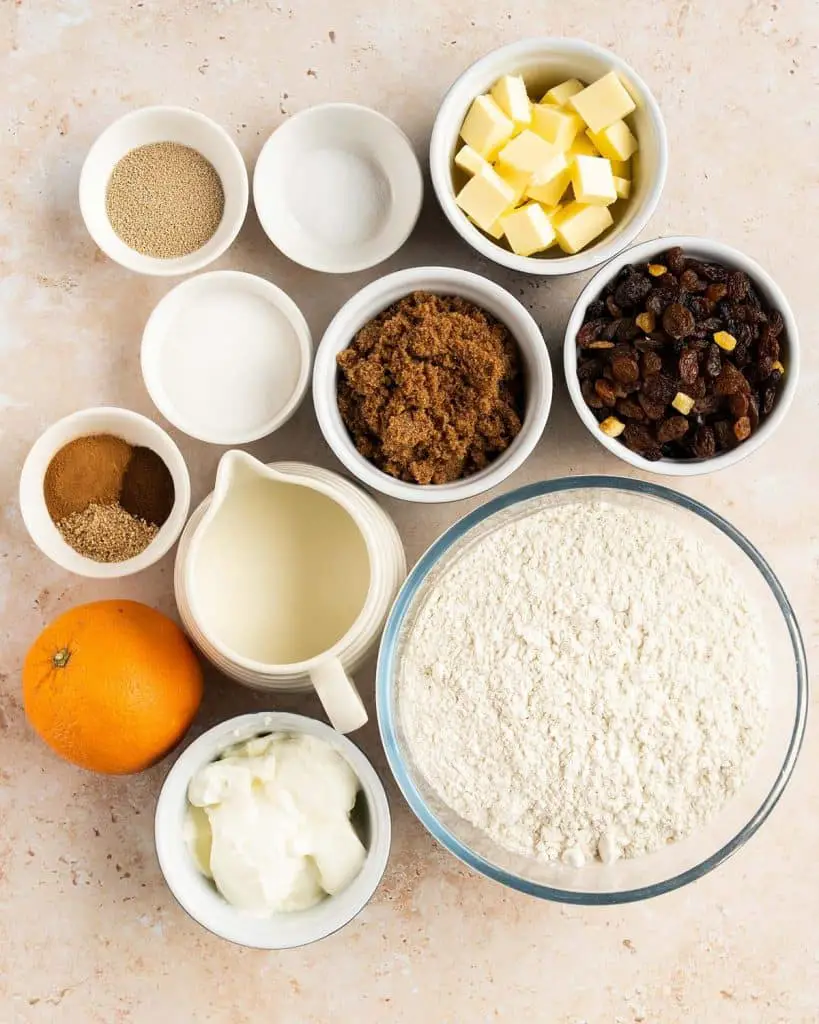 Ingredients for the rolls: whole milk, caster sugar, dried active yeast, strong white bread flour, salt, spices, unsalted butter, yogurt, orange (zest only), dried fruit, brown sugar and cinnamon. Recipe by movers and bakers