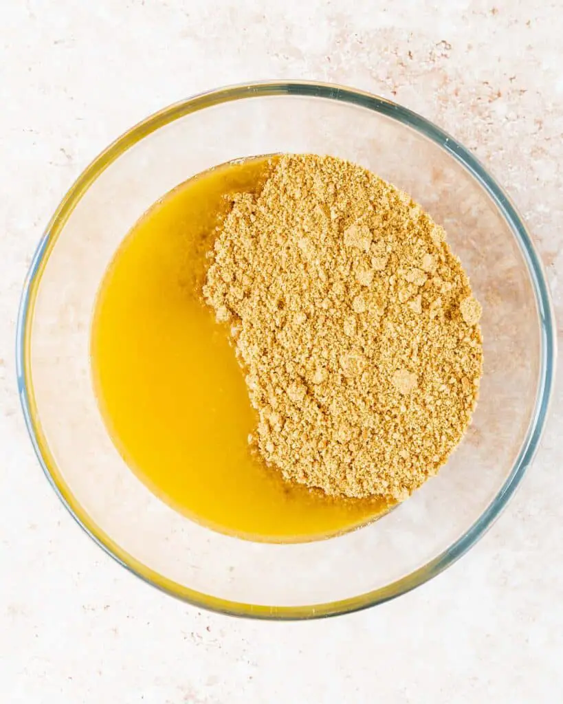 Tip the crushed biscuits into a bowl with the melted butter...