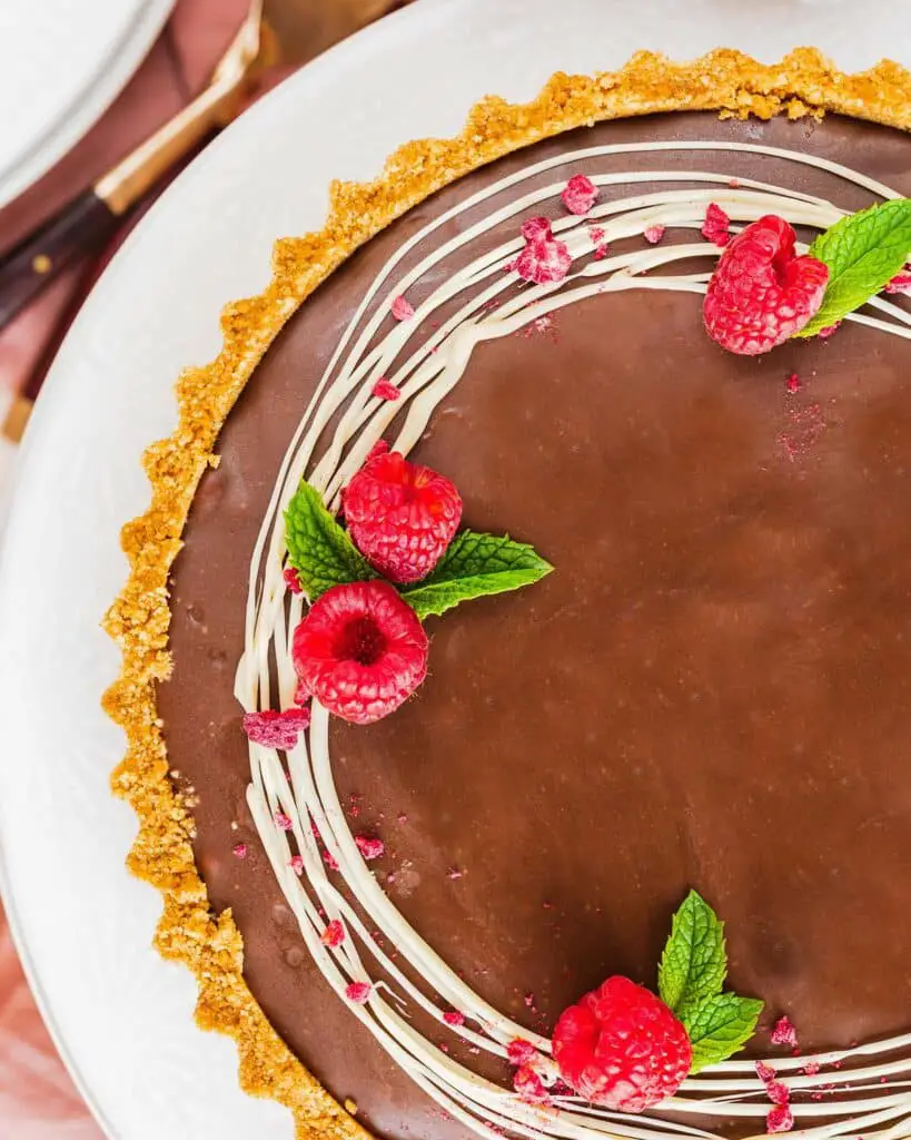 My chocolate raspberry tart is the perfect dessert for sophisticated and elegant entertaining, but with minimal and easy prep! Buttery biscuit base, fresh tart raspberries and a smooth and creamy milk chocolate filling make this a dreamy dessert everyone will love. Recipe by movers and bakers