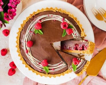 My chocolate raspberry tart is the perfect dessert for sophisticated and elegant entertaining, but with minimal and easy prep! Buttery biscuit base, fresh tart raspberries and a smooth and creamy milk chocolate filling make this a dreamy dessert everyone will love. Recipe by movers and bakers