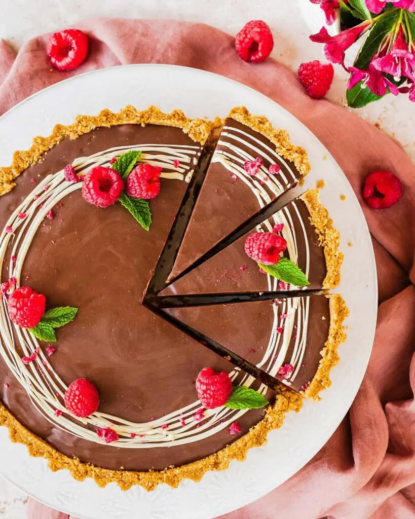 My chocolate raspberry tart is the perfect dessert for sophisticated and elegant entertaining, but with minimal and easy prep! Buttery biscuit base, fresh tart raspberries and a smooth and creamy milk chocolate filling make this a dreamy dessert everyone will love. Recipe by movers and bakers