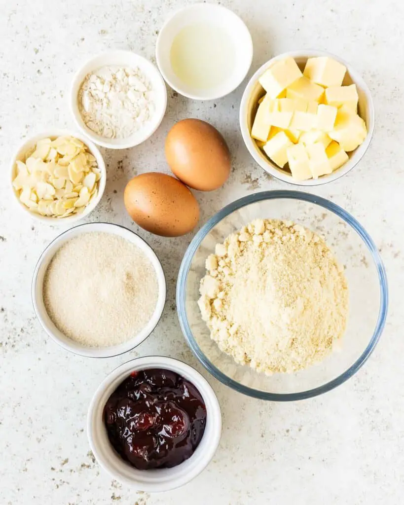Ingredients for the filling: unsalted butter, golden caster sugar, eggs, ground almonds, plain (all purpose) flour, almond extract, raspberry jam, flaked almonds and icing sugar. Recipe by movers and bakers